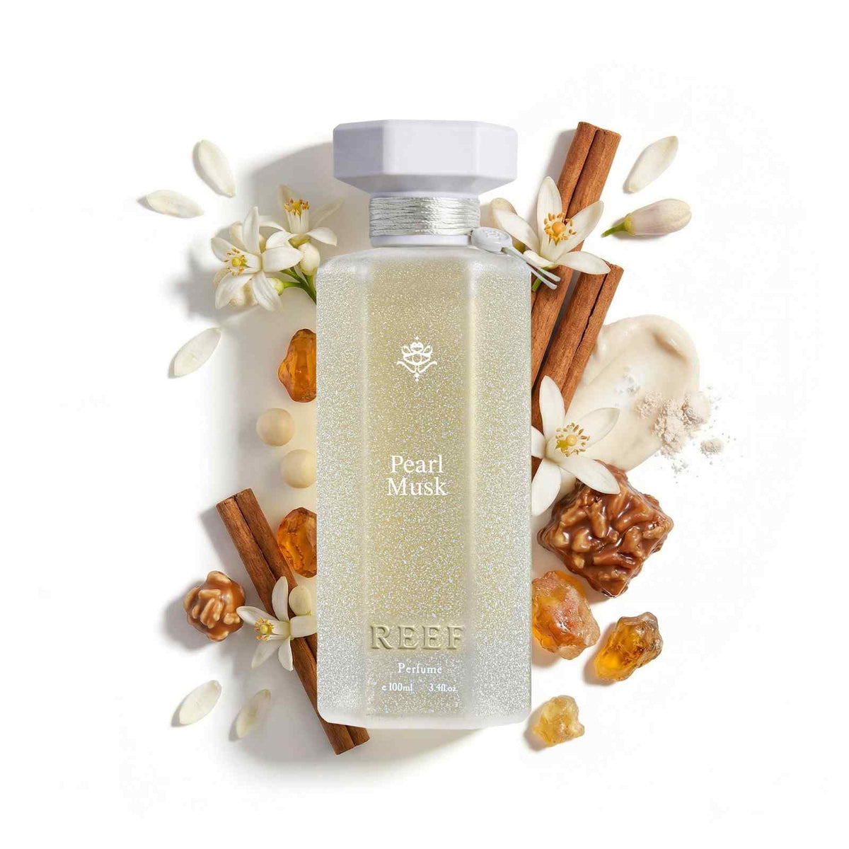 Pearl Musk perfume bottle with cinnamon sticks, white flowers, and amber accents