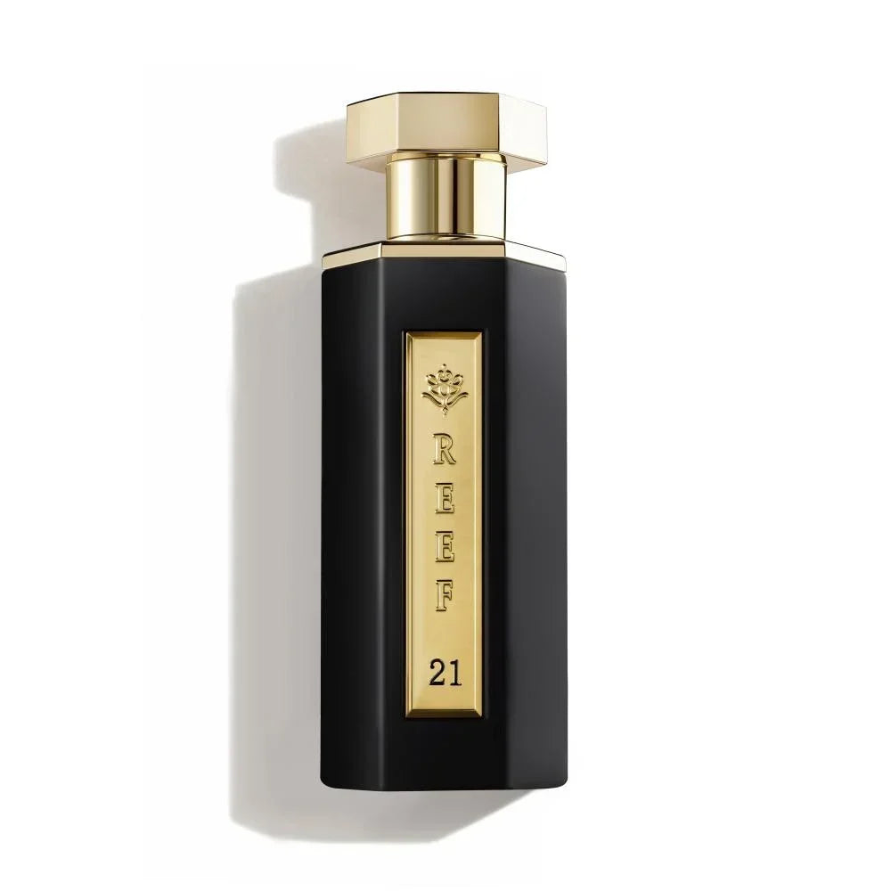 Elegant black perfume bottle with gold accents, labeled REEF 21, evoking luxury and oriental fragrance notes