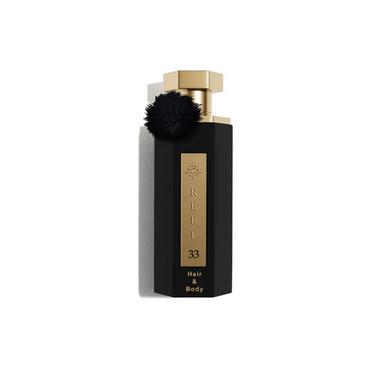 Luxury black perfume bottle with gold cap and black pom-pom, REEF 33 Hair & Body